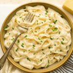Creamy cottage cheese pasta sauce in a bowl with herbs and pasta