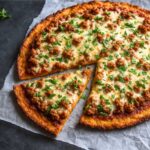 Ground chicken pizza crust topped with fresh veggies and cheese