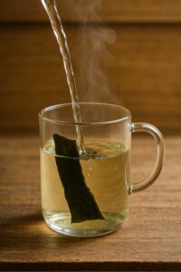 Pouring hot water over kombu in a glass mug for japanese mounjaro recipe