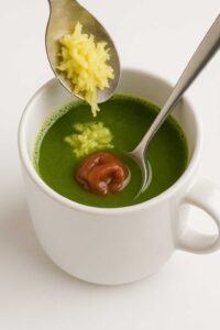 Adding grated ginger and umeboshi to natural mounjaro recipe in a mug