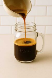 Brewed espresso poured into a mason jar for iced brown sugar oatmilk shaken espresso