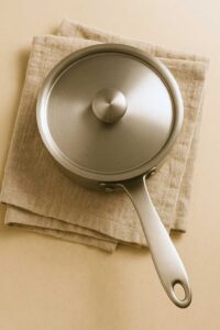 Covered saucepan resting on a linen towel for Costa Rican tea recipe